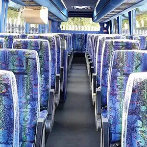 the inside of a bus with blue seats